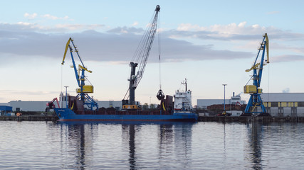Fototapeta premium cranes at harbor against sky