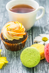 Still life with cup of tea and cake on the wooden background