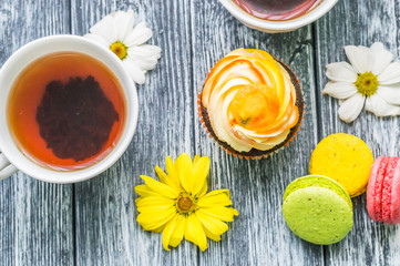 Still life with cup of tea and cake on the wooden background