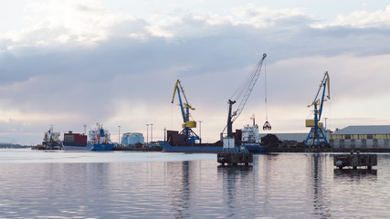 Fototapeta premium cranes at harbor against sky