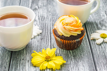 Still life with cup of tea and cake on the wooden background