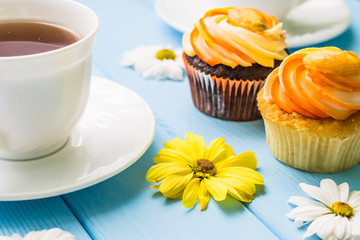 Still life with cup of tea and cake on the wooden background