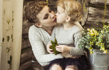 concept of motherhood:loving mother kisses his little daughter