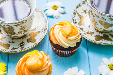 Still life with cup of tea and cake on the wooden background