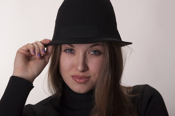 Portrait of a beautiful girl with long hair in a hat
