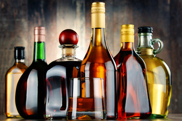 Fototapeta na wymiar Glass and bottles of assorted alcoholic beverages