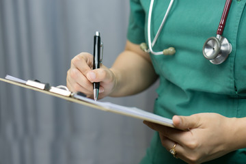 female doctor,surgeon,nurse,pharmacy with stethoscope on hospital holding clipboard,writing a prescription,Medical Exam,Healthcare and medical concept,test results,vintage color,selective focus