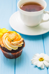 Still life with cup of tea and cake on the wooden background