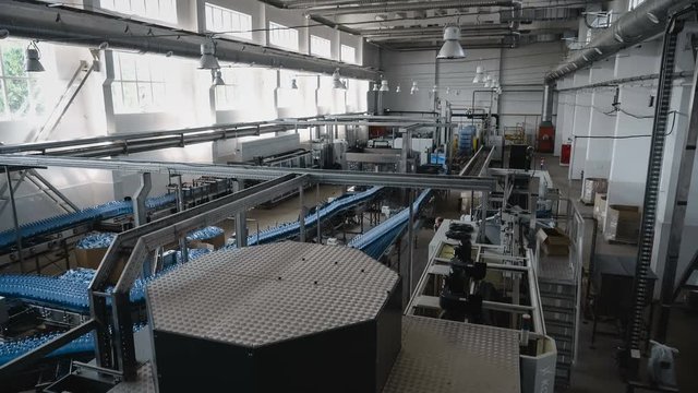 Time lapse wide shot of water filling line - Water bottling line for processing and bottling pure mineral water into blue bottles.