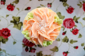 Tasty cupcake on floral table sheet background