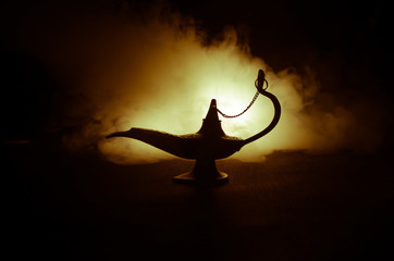 Antique Aladdin arabian nights genie style oil lamp with soft light white smoke, Dark background....