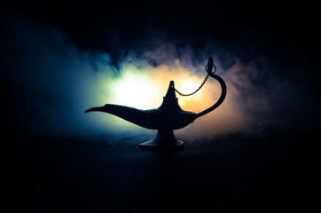 Antique Aladdin arabian nights genie style oil lamp with soft light white smoke, Dark background....