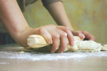 female hands rolling dough