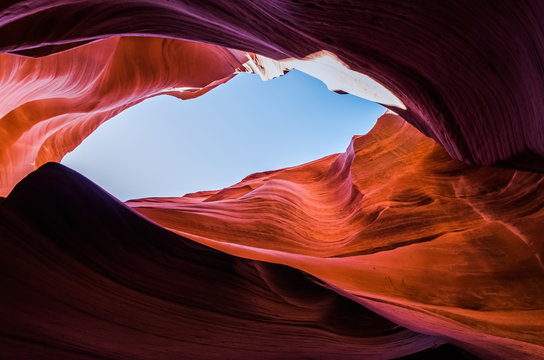 Pink peach wave shapes photographed at slots canyons in Arizona with blue sky