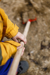 detail of child in overalls with shovel in action - boy in workwear
