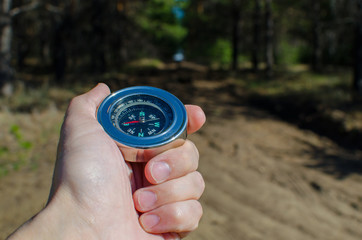 Male hand holding a compass