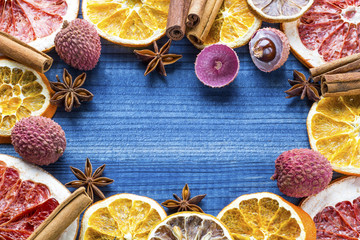 Lychee fruits with citrus slices and star anise on wooden background