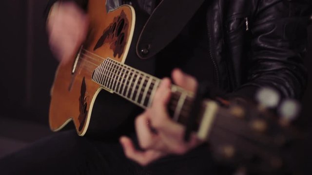 Face and Hands of a Bearded Man Playing Guitar