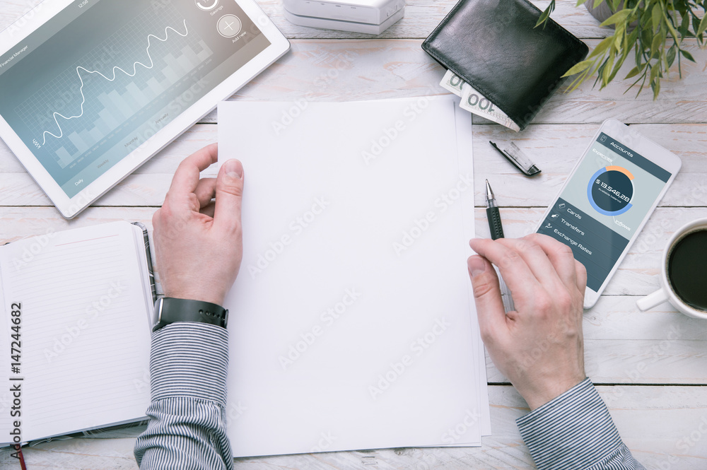 Fototapete man holds a piece of paper with empty space for your text. tablet and smartphone over the desk with 