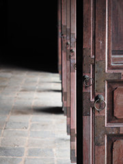 Light coming to the temple through opened wooden ancient door.