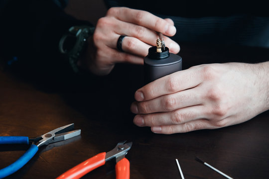 male master installs a coyle. Spiral for electronic evaporator and cigarette. Vape, vaping. Pliers, wire, fichral, coil, screwdriver