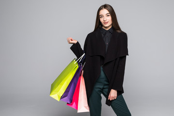 Young beautiful woman with shopping bag on grey