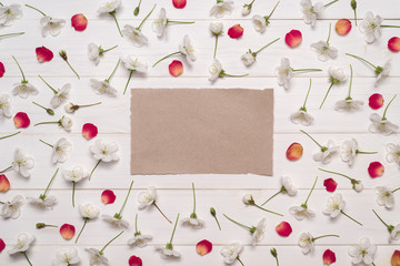 Fototapeta na wymiar Decorative frame of white cherry flowers and red petals