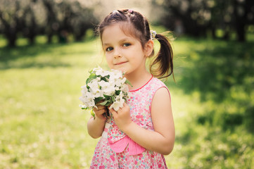 spring closeup outdoor portrait of adorable kid girl. Spending spring holidays in beautiful blooming garden