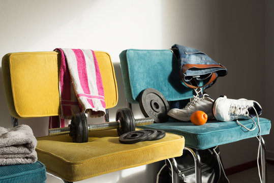Detail of a teenager's room with dumbells, towel and shoes. Interior sports and gym concept.