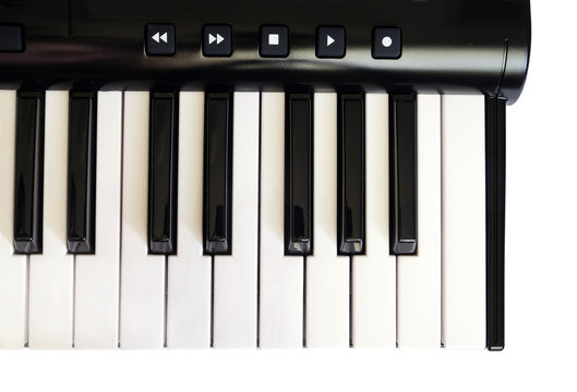 Piano keyboard with white and black keys isolated on blue jeans background front view vertical  photo close up