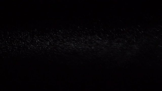 Some dust of liquid particles flowing on dark background