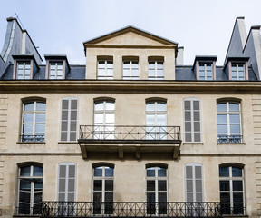 Obraz premium Generic historic building in Paris, France, with beautiful balconets, balconies and dormer windows at the attic with a contrast processing