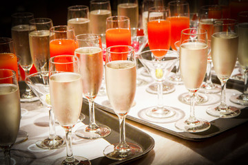 Row of glasses filled with champagne lined up ready to be served