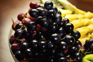 Fruits on a plate,Exotic fruits,Pineapple, grapes, oranges and kiwi,Fruit slicing,Very tasty fruit,Healthy eating habits, diet food