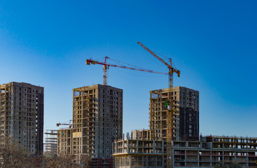 Fototapeta na wymiar Construction cranes and tall buildings