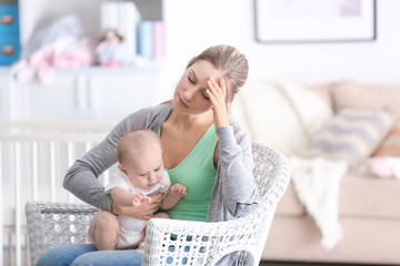 Depressed young woman with cute baby at home