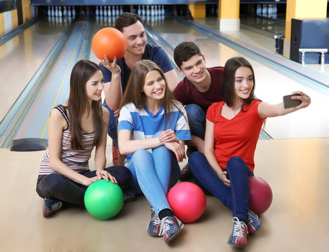 Friends taking selfie in bowling club