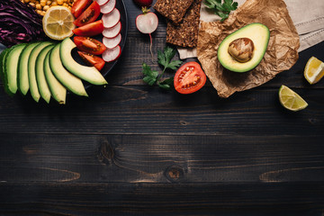 Healthy vegan food concept. Healthy food with vegetables and whole wheat bread on the wooden table top view. Copy space