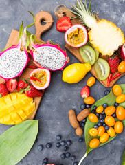 Exotic fruits. Summer photo concept. Mango. Papaya. A pineapple. Avocado. Kiwi. Pitahaya. Kumhvat. Copyspase. Fresh fruits. Exotic fruits on a gray background. Blueberry. Strawberry.  Lemon.