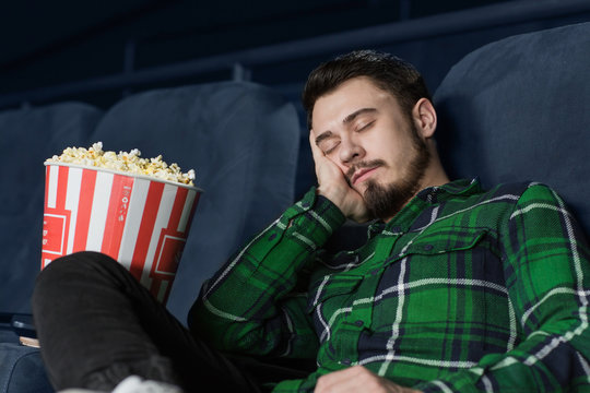 Bored young man at the movie theatre