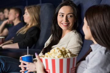 Two female friends watching a movie at the cinema together