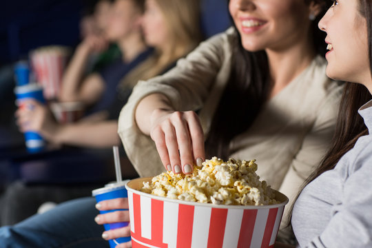 Two Female Friends Watching A Movie At The Cinema Together