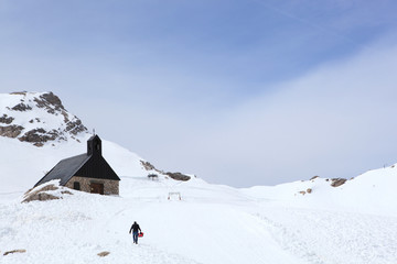 Winter snow covered mountain Zugspitze in Germany Europe. Great place for winter sports , man walking with snowshoes on a beautiful sunny day in the mountain full of snow