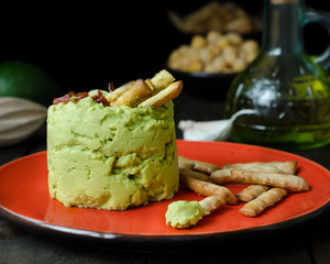 Avocado Hummus with mini grissini, rustic still life