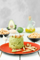 Avocado Hummus with mini grissini, rustic still life