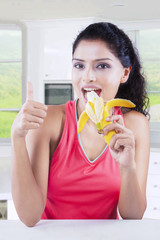 Young woman eating a fresh banana