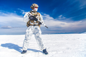Army serviceman in winter camo somewhere in the Arctic. He wears chest rig and huge backpack,...