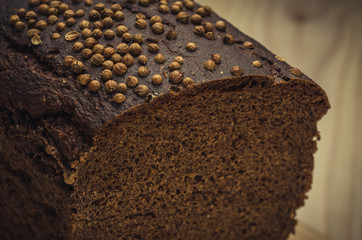 black bread on the wooden background/piece of black bread close up