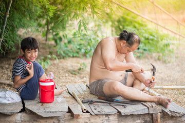 Family son and father making table by bamboo tree together country side outdoor activity