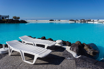 Chaises longues au bord de la piscine